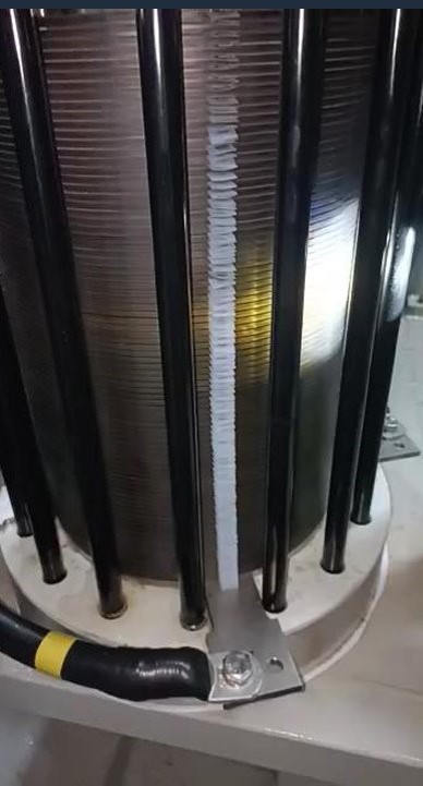 Vista aproximada de um equipamento industrial com elementos verticais e conexões na base.