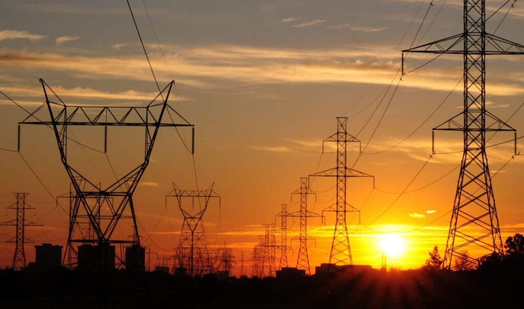 Linhas e torres de transmissão de energia ao pôr do sol